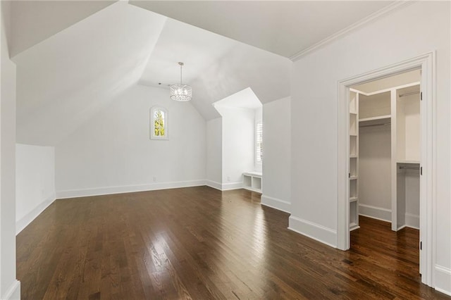 additional living space featuring vaulted ceiling, an inviting chandelier, and dark hardwood / wood-style flooring