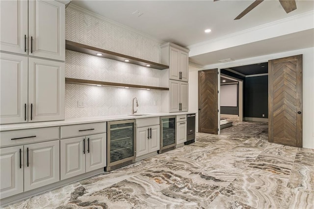 kitchen featuring ornamental molding, sink, and beverage cooler