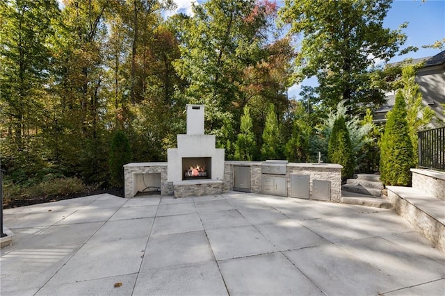 view of patio / terrace with an outdoor fireplace, grilling area, and an outdoor kitchen