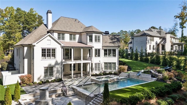 rear view of house featuring a patio, a pool with hot tub, and a yard