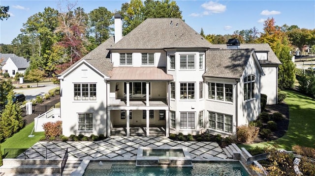 back of property with a yard, a patio area, and a balcony