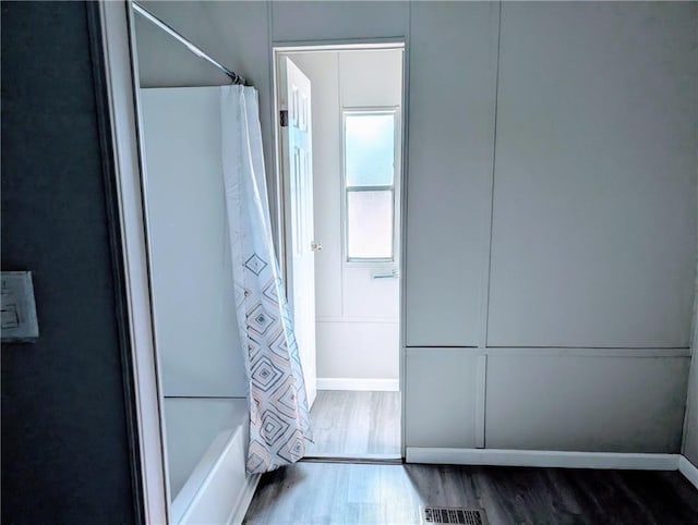 bathroom with shower / tub combo with curtain and hardwood / wood-style flooring