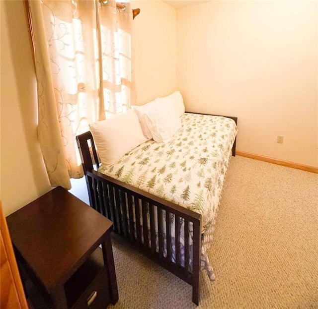 carpeted bedroom featuring baseboards