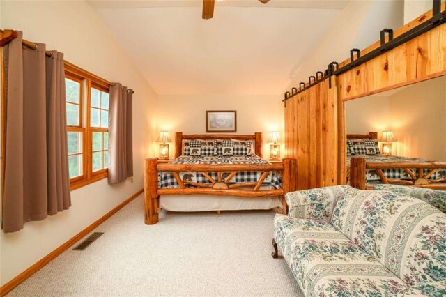 carpeted bedroom with a barn door, baseboards, visible vents, and vaulted ceiling