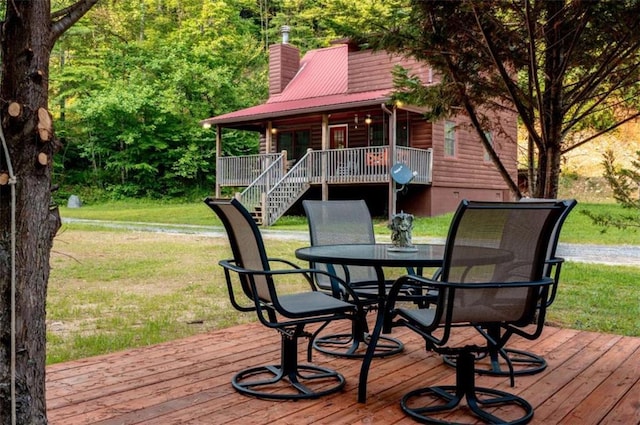 deck featuring a lawn, stairs, and outdoor dining area