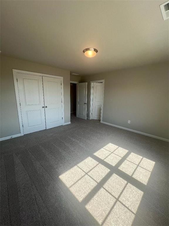 unfurnished bedroom with a closet and carpet flooring