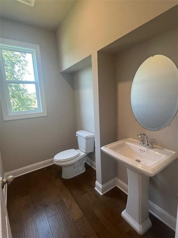 bathroom featuring hardwood / wood-style flooring and toilet