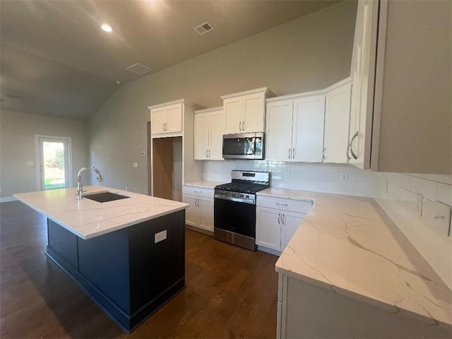 kitchen with sink, stainless steel appliances, an island with sink, white cabinets, and lofted ceiling