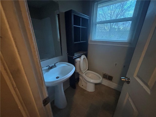 bathroom with toilet, baseboards, and visible vents