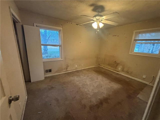 unfurnished bedroom featuring multiple windows, carpet, visible vents, and baseboards