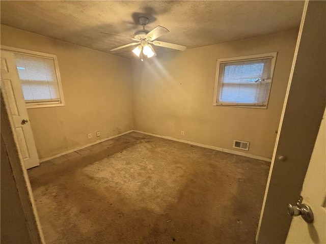 unfurnished bedroom with carpet floors, visible vents, ceiling fan, a textured ceiling, and baseboards