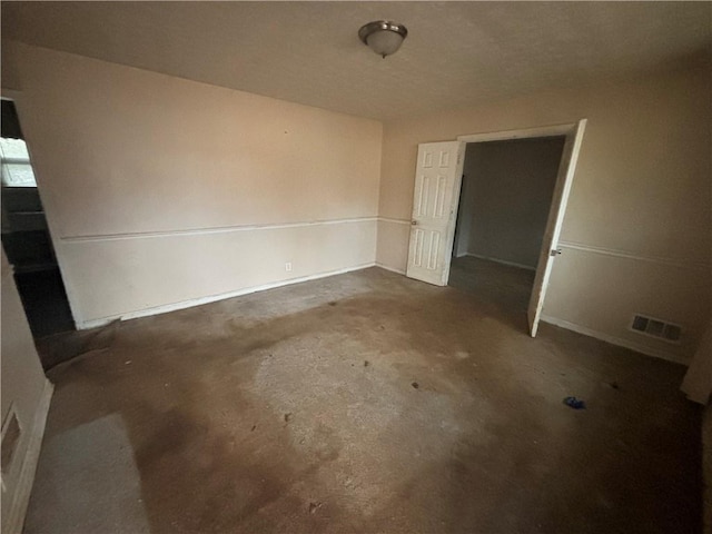 spare room featuring concrete floors and visible vents