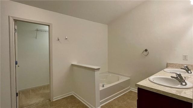 bathroom featuring tile patterned floors, double vanity, a sink, and a bath