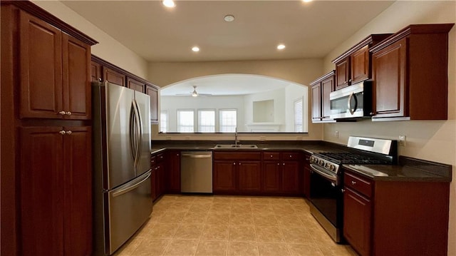 kitchen with arched walkways, stainless steel appliances, recessed lighting, a sink, and ceiling fan