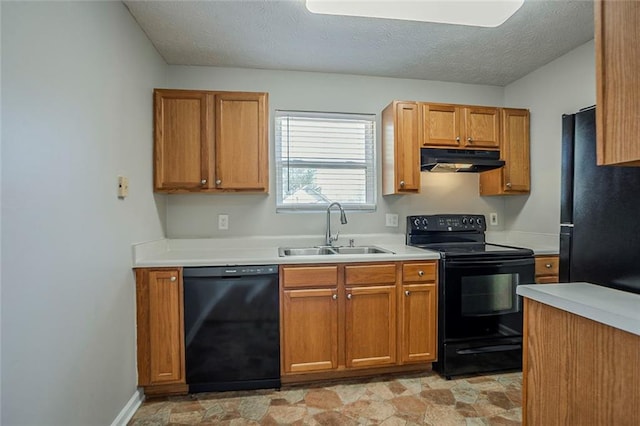 kitchen with a textured ceiling, under cabinet range hood, a sink, light countertops, and black appliances