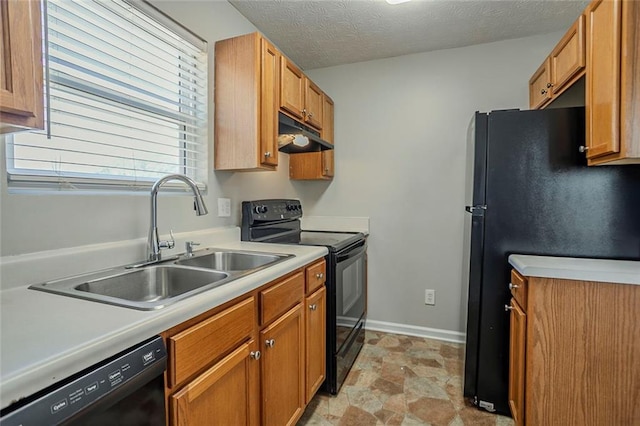 kitchen featuring under cabinet range hood, light countertops, a textured ceiling, black appliances, and a sink