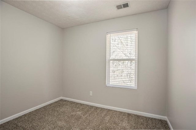 empty room featuring a healthy amount of sunlight, visible vents, baseboards, and carpet flooring