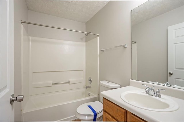 full bath featuring toilet, tub / shower combination, a textured ceiling, and vanity