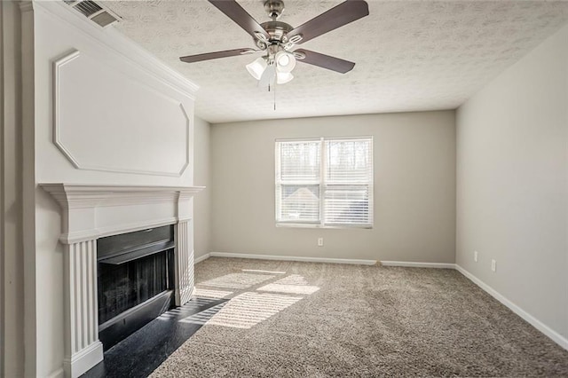 unfurnished living room featuring carpet, visible vents, a fireplace with flush hearth, a textured ceiling, and baseboards