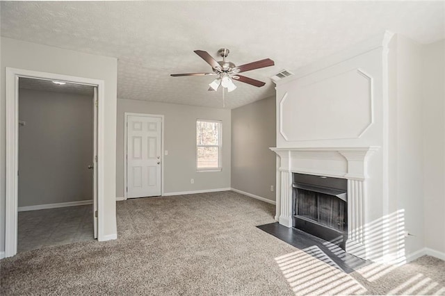 unfurnished living room featuring visible vents, a fireplace with flush hearth, carpet flooring, ceiling fan, and a textured ceiling