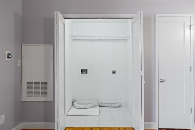 laundry room featuring baseboards, hookup for an electric dryer, tile patterned floors, and laundry area