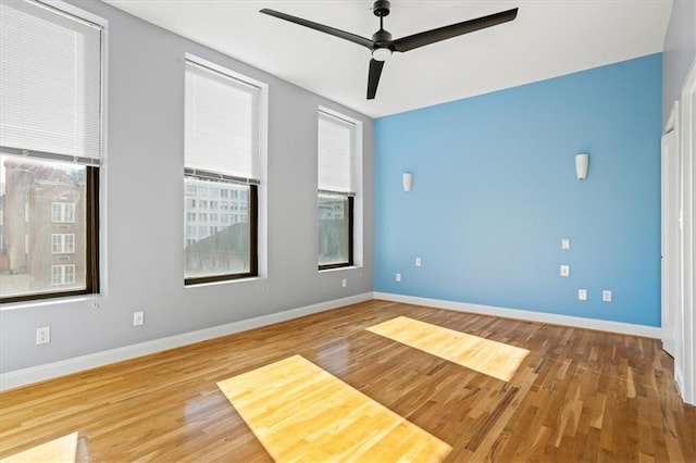 unfurnished room featuring baseboards, a ceiling fan, and wood finished floors