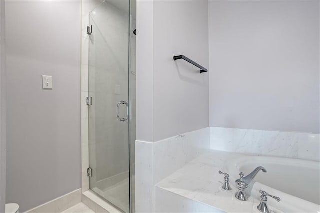 full bathroom featuring a bath and a stall shower