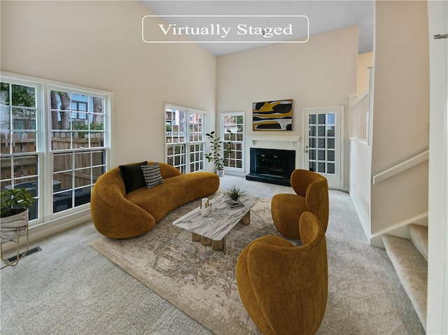 living room with light colored carpet and a high ceiling