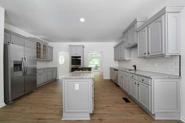 1460 Bakers Bridge Rd, Douglasville, GA 30134 - kitchen featuring stainless steel appliances, gray cabinetry, a kitchen island, tasteful backsplash, and a sink