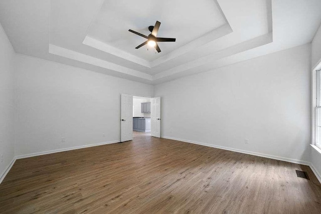 1460 Bakers Bridge Rd, Douglasville, GA 30134 - spare room featuring a tray ceiling, dark wood finished floors, and a ceiling fan