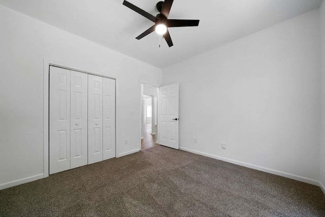 1460 Bakers Bridge Rd, Douglasville, GA 30134 - unfurnished bedroom with dark carpet, baseboards, a closet, and a ceiling fan