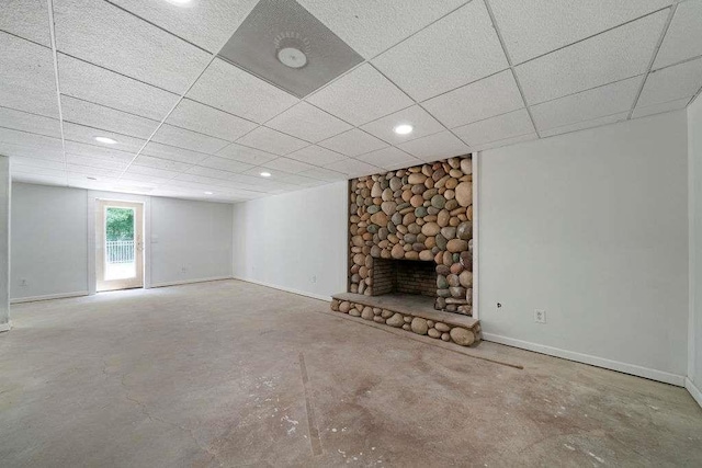 1460 Bakers Bridge Rd, Douglasville, GA 30134 - unfurnished living room with concrete flooring, a stone fireplace, baseboards, a paneled ceiling, and recessed lighting