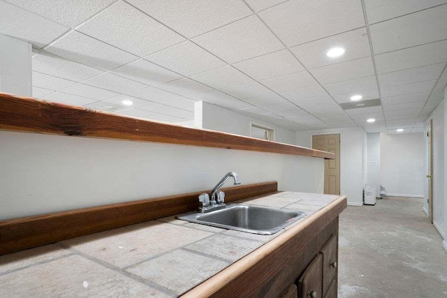 1460 Bakers Bridge Rd, Douglasville, GA 30134 - kitchen with a sink, recessed lighting, a paneled ceiling, tile counters, and baseboards