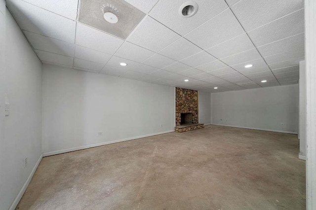 1460 Bakers Bridge Rd, Douglasville, GA 30134 - unfurnished living room featuring baseboards, a drop ceiling, concrete floors, a stone fireplace, and recessed lighting