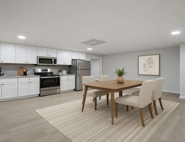 1460 Bakers Bridge Rd, Douglasville, GA 30134 - dining space featuring light wood-type flooring, baseboards, and a paneled ceiling