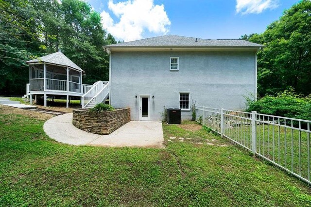 1460 Bakers Bridge Rd, Douglasville, GA 30134 - rear view of house featuring a gazebo, stucco siding, a patio area, and cooling unit