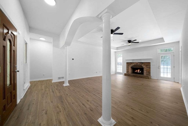 1460 Bakers Bridge Rd, Douglasville, GA 30134 - unfurnished living room with ornate columns, a raised ceiling, wood finished floors, and plenty of natural light