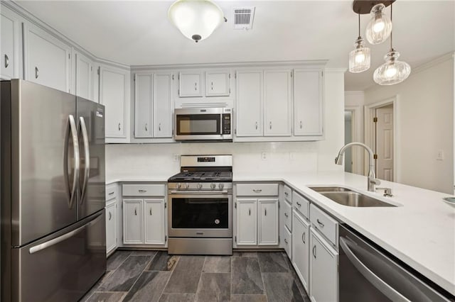 kitchen with a sink, visible vents, light countertops, ornamental molding, and appliances with stainless steel finishes