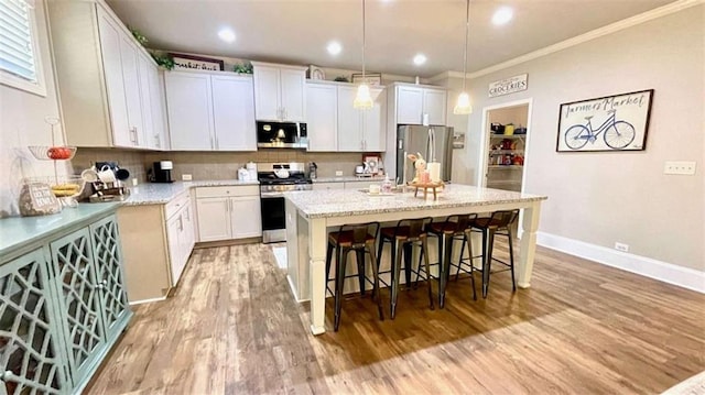 109 Red Fox Dr, Dallas, GA 30157 - kitchen with stainless steel appliances, ornamental molding, light wood-type flooring, a kitchen island with sink, and backsplash