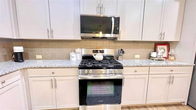 109 Red Fox Dr, Dallas, GA 30157 - kitchen featuring stainless steel appliances, light stone counters, backsplash, and white cabinets