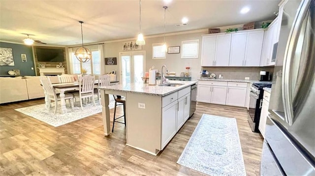 109 Red Fox Dr, Dallas, GA 30157 - kitchen featuring appliances with stainless steel finishes, ornamental molding, white cabinetry, a breakfast bar area, and light wood-style floors