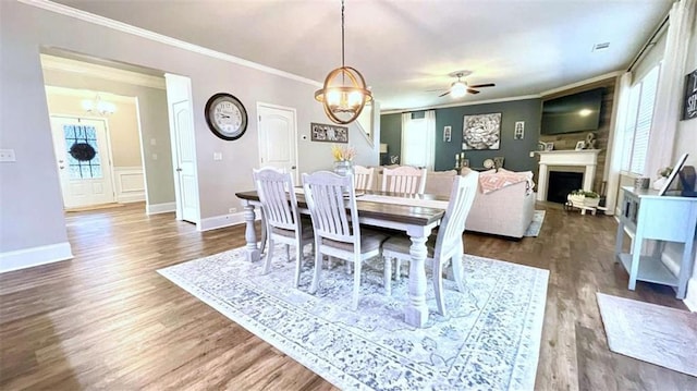 109 Red Fox Dr, Dallas, GA 30157 - dining space with a chandelier, ornamental molding, dark wood-style flooring, a fireplace, and ceiling fan