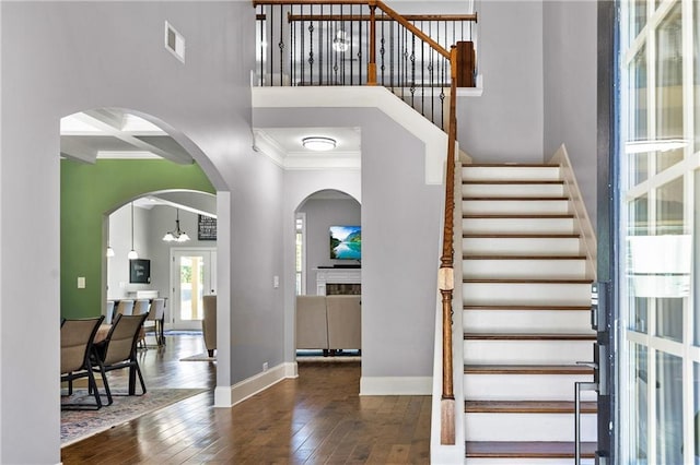 entrance foyer featuring dark wood-style flooring, coffered ceiling, visible vents, baseboards, and ornamental molding