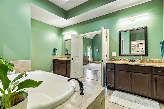 bathroom featuring a garden tub and vanity