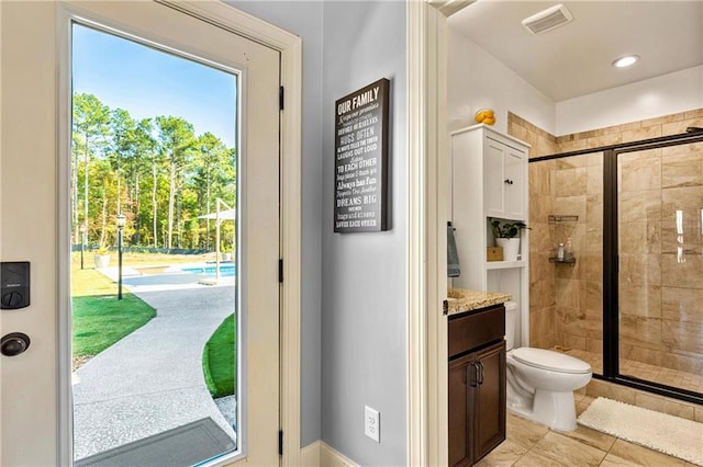 bathroom with visible vents, toilet, a shower stall, and vanity