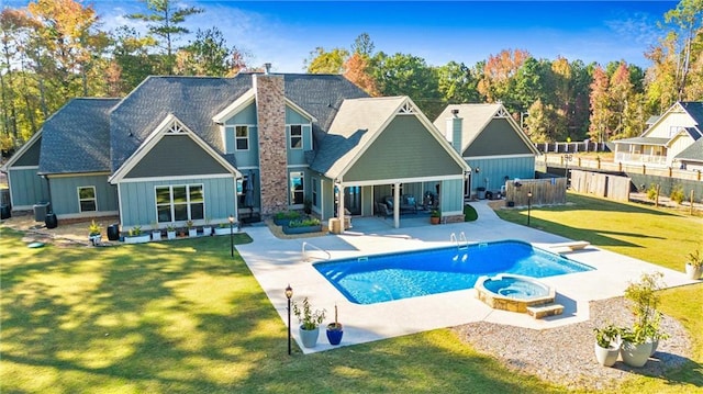 rear view of property with a patio, a yard, and a chimney