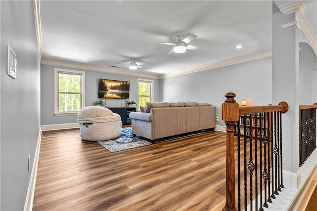 living area with plenty of natural light, crown molding, and wood finished floors