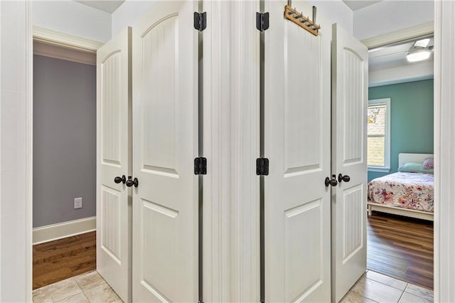 hall featuring light wood-type flooring and baseboards