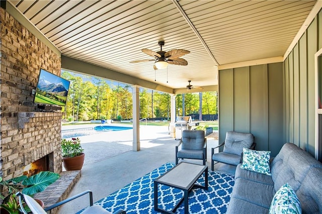 view of patio / terrace with ceiling fan, an outdoor living space with a fireplace, and an outdoor pool