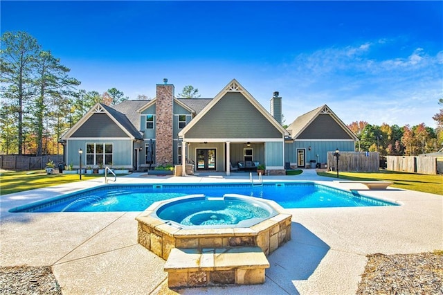 view of pool featuring a diving board, a patio area, fence, and a pool with connected hot tub